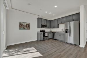 a kitchen with grey cabinets and a wood floor